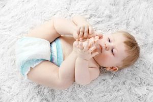 bigstock-Cute-baby-boy-on-carpet-on-li-86890337-e1571227362559