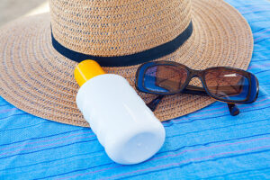 Sunscreen, hat and glasses on beach . Day with sunny in Çeşme,Turkey.