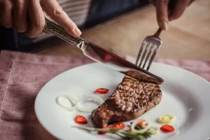 depositphotos_139875342-stock-photo-woman-eating-steak